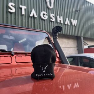 Stagshaw Land Rover dealership with a black beanie hat and vehicle in front.